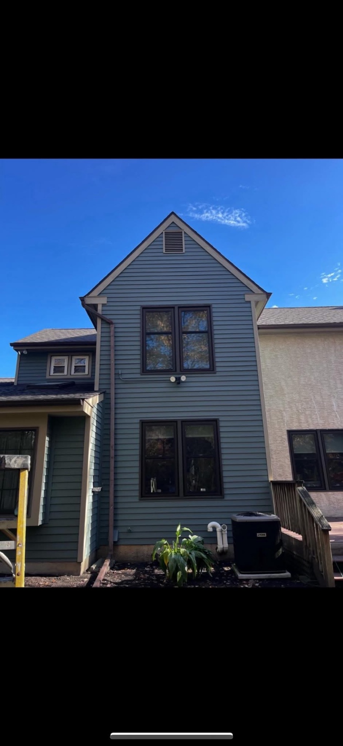 Blue painted house exterior with dark windows