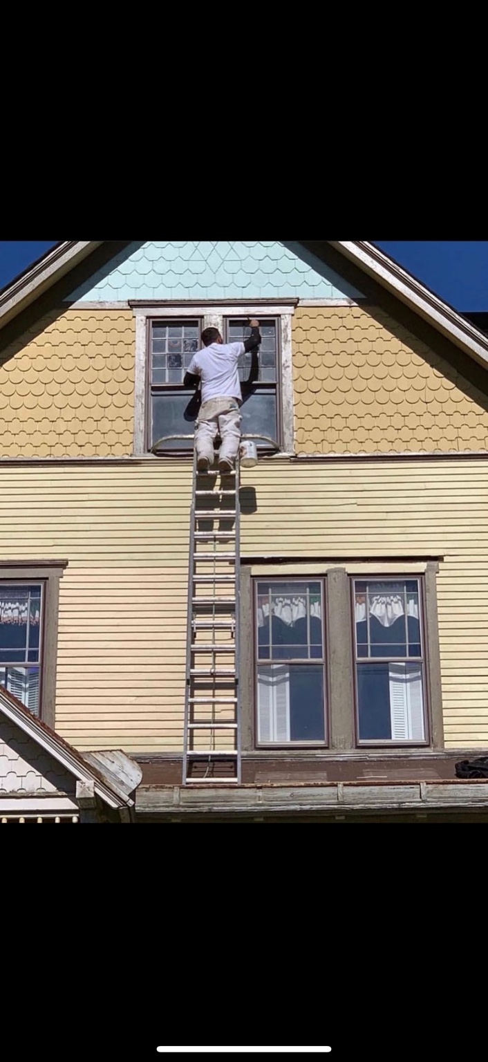 Painter restoring exterior window trim